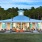 The Lakehouse lit up in early evening with seating around outdoor fire pit at The Laurent at Carolina Forest