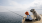 Child fishes on a pier as her dog sits beside her